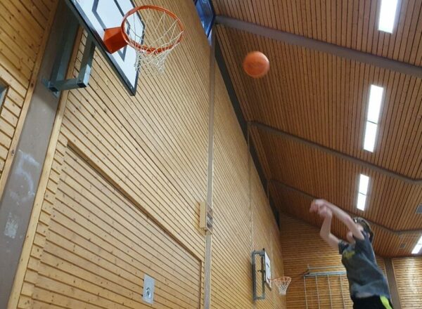 Schüler in der Abwurfsituation eines Basketballs auf den Korb