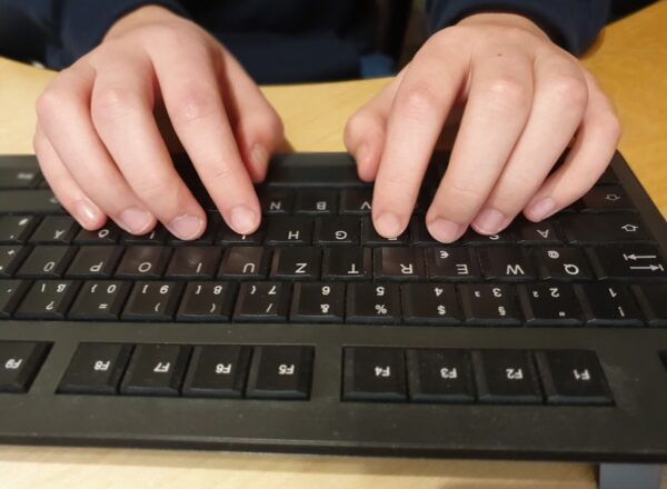 Hände liegen in der 10-Finger-Ausgangssituation auf einer PC-Tatstatur